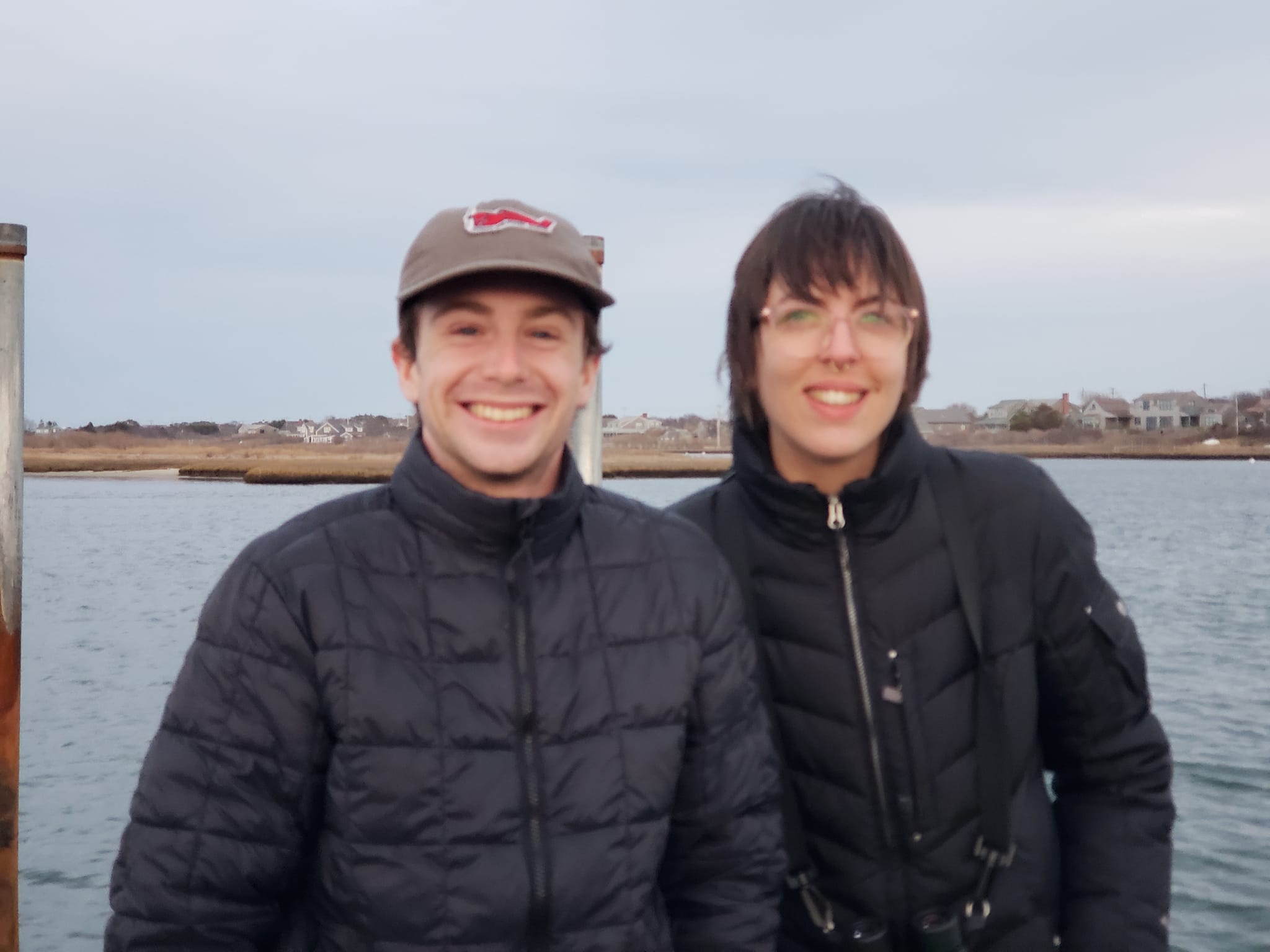 two student interns by the shore looking into the camera