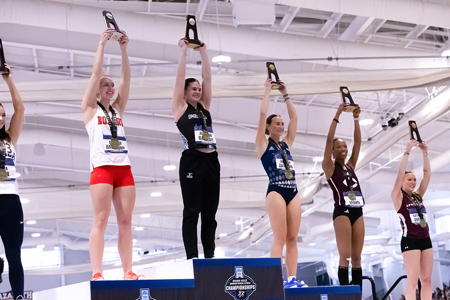 Aryianna Garceau (center) stands on the podium with her medal.