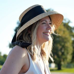 Woman with blond hair in profile with a sunhat on a sunny day