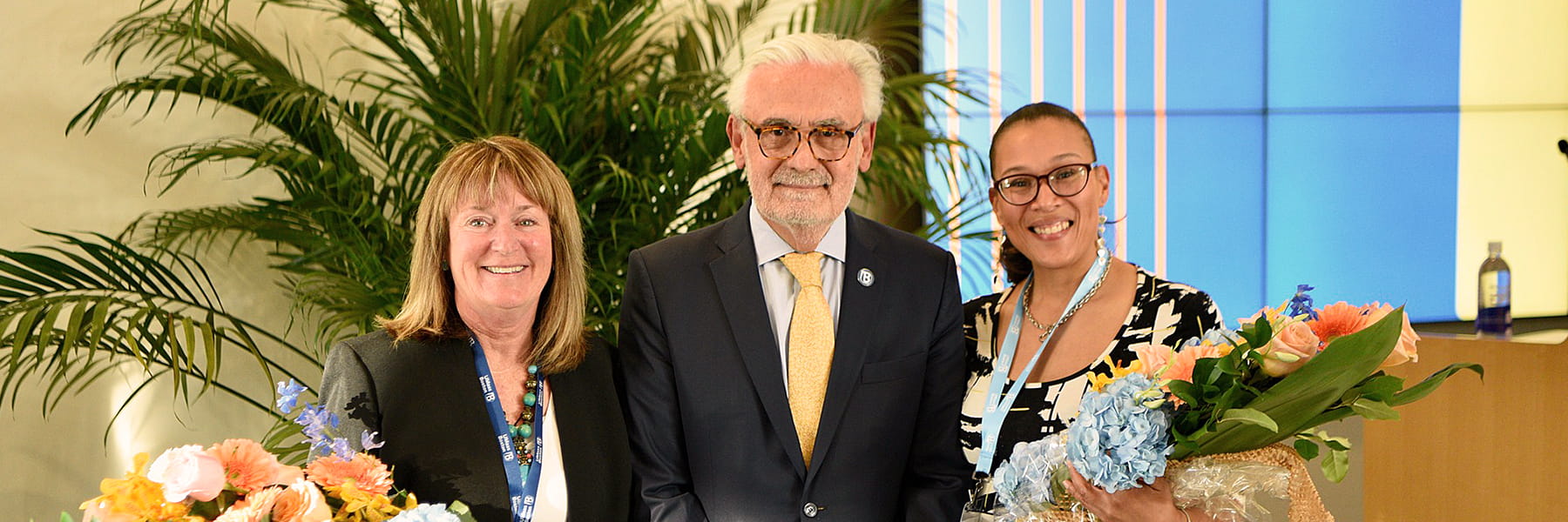 two women with bouquets pose with the chancellor